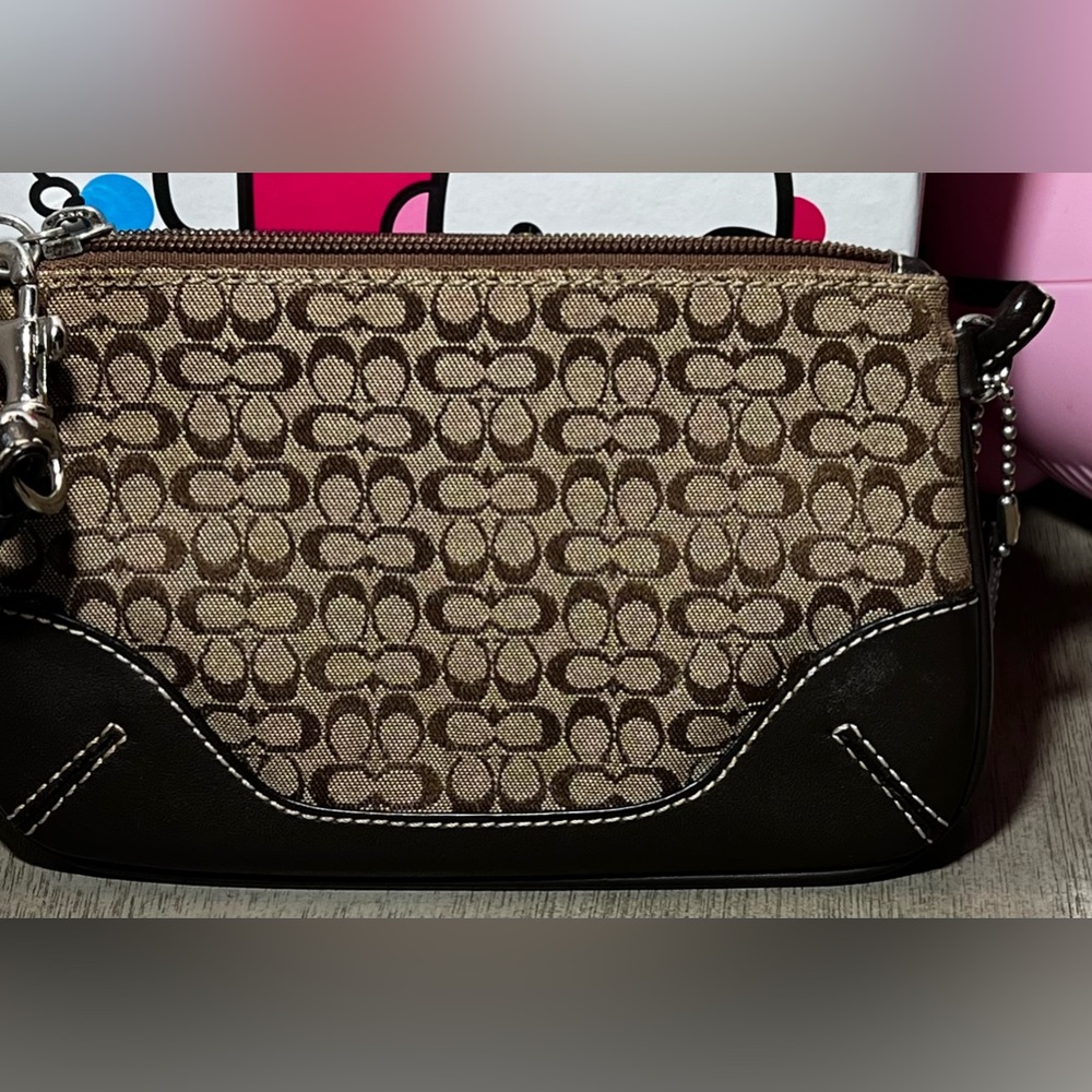 Coach wristlet small cc pattern on brown jacquard with dark brown leather trim.